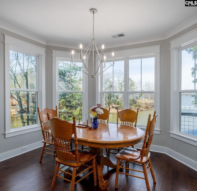 dining area with a notable chandelier, visible vents, dark wood-type flooring, ornamental molding, and baseboards