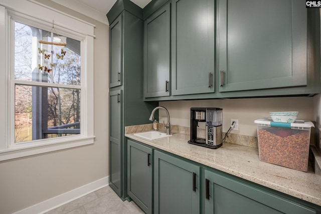 bar featuring baseboards, a sink, and light tile patterned flooring