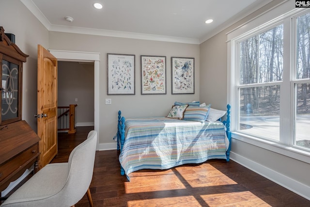 bedroom featuring multiple windows, baseboards, and wood finished floors