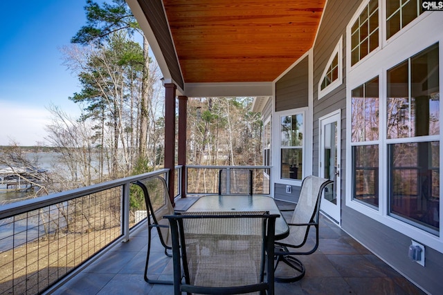 balcony with a sunroom and outdoor dining area