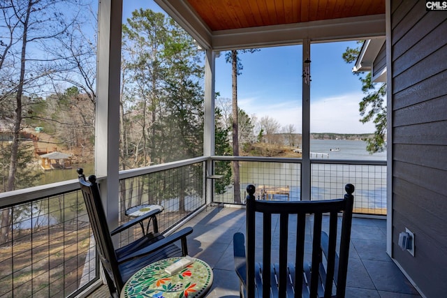 exterior space with a water view and wooden ceiling