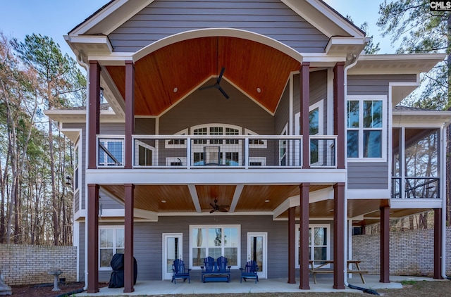 rear view of property with a balcony, a patio area, fence, and outdoor lounge area