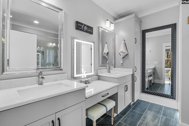 bathroom featuring a shower stall, two vanities, a sink, and crown molding