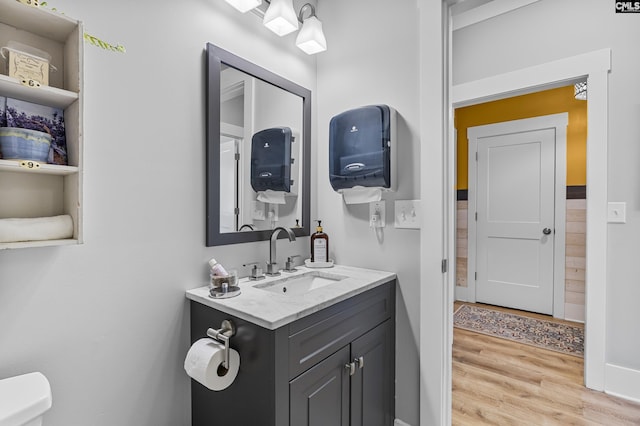 bathroom featuring toilet, wood finished floors, and vanity