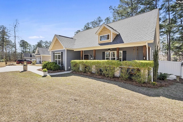 view of front of home featuring a shingled roof and fence