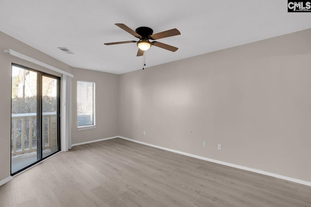 empty room with visible vents, a ceiling fan, light wood-style flooring, and baseboards