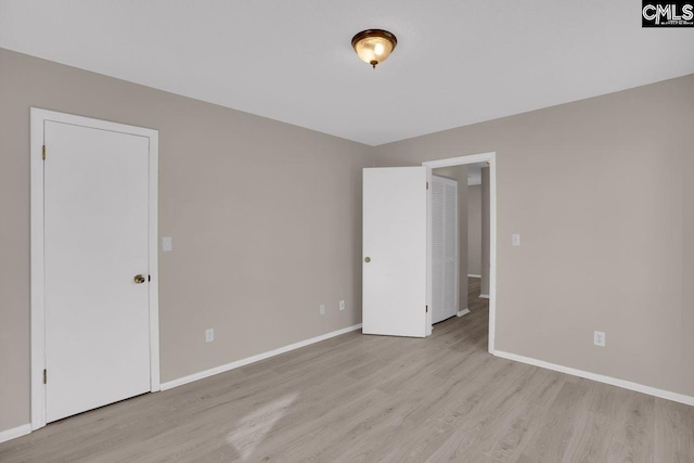 spare room with light wood-style floors and baseboards