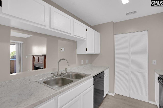 kitchen with light countertops, black dishwasher, visible vents, and a sink