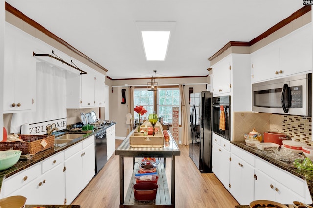 kitchen featuring black appliances, white cabinets, and crown molding