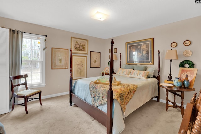 bedroom with baseboards and light colored carpet