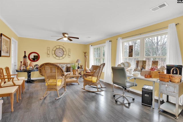 interior space with baseboards, visible vents, a ceiling fan, ornamental molding, and dark wood-style flooring