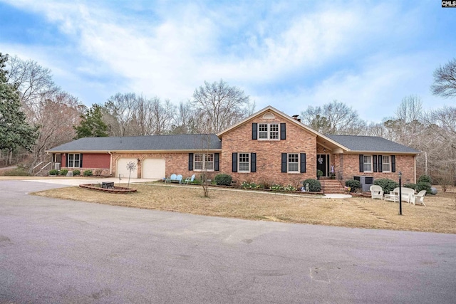 view of front of property with driveway, brick siding, and an attached garage