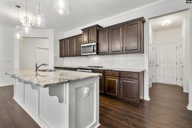 kitchen featuring stainless steel appliances, a sink, a kitchen breakfast bar, and tasteful backsplash