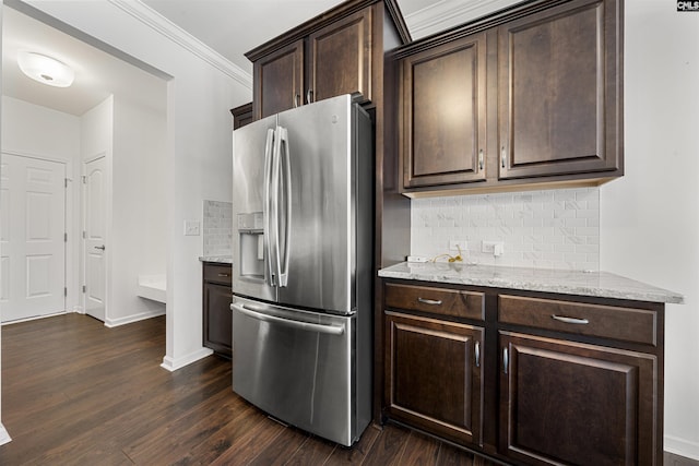 kitchen with light stone counters, dark wood-type flooring, dark brown cabinets, ornamental molding, and stainless steel refrigerator with ice dispenser