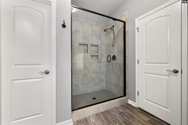 bathroom featuring a shower stall and wood finished floors