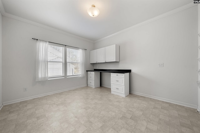 unfurnished office featuring light floors, crown molding, built in desk, and baseboards