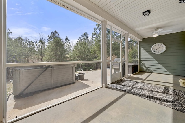 unfurnished sunroom featuring a ceiling fan