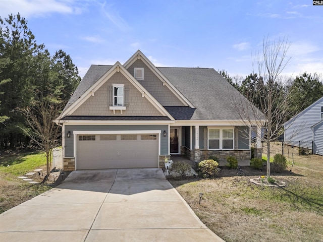 craftsman house featuring an attached garage, stone siding, concrete driveway, and roof with shingles