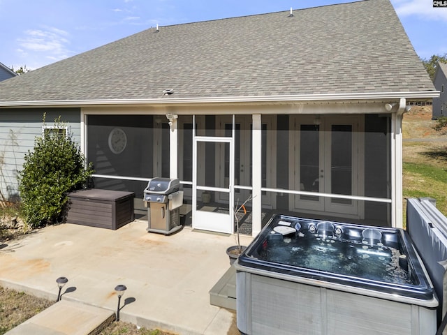 view of patio / terrace featuring a sunroom, a hot tub, and grilling area