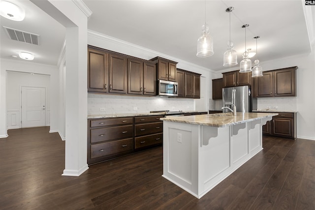 kitchen with a breakfast bar, dark wood finished floors, stainless steel appliances, visible vents, and dark brown cabinetry