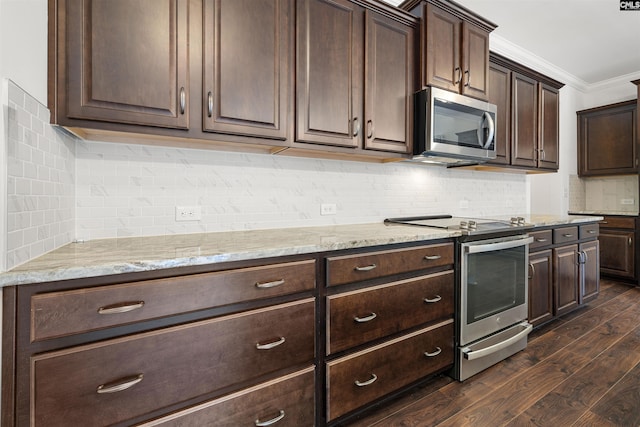 kitchen with dark wood-type flooring, dark brown cabinets, appliances with stainless steel finishes, light stone countertops, and crown molding