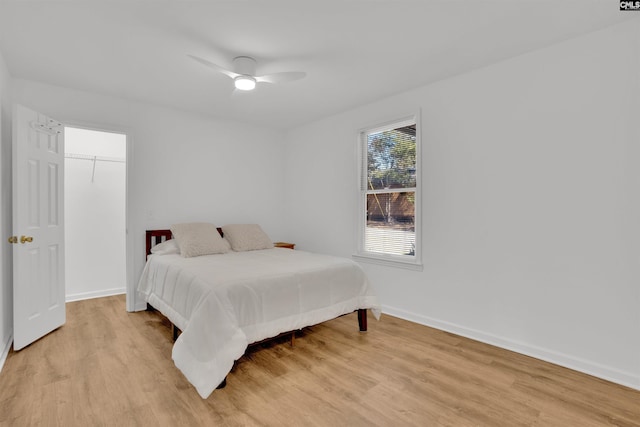 bedroom with light wood finished floors, a ceiling fan, and baseboards