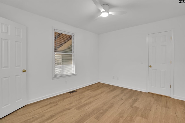 empty room with baseboards, light wood-style flooring, visible vents, and a ceiling fan