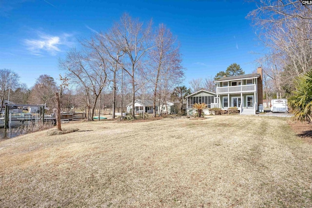 view of yard featuring a sunroom and driveway