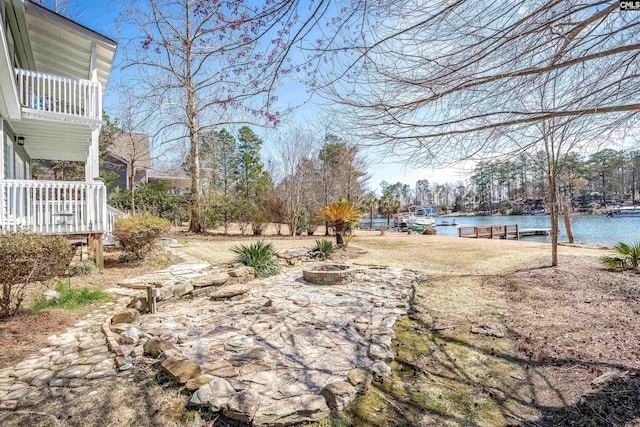 view of yard with a fire pit and a water view