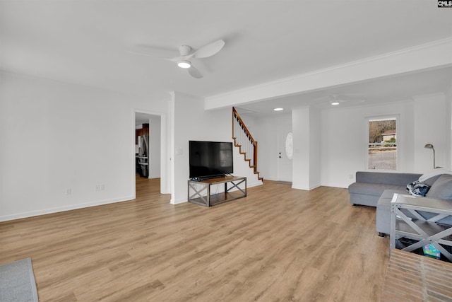 living room with a ceiling fan, stairway, light wood-style flooring, and baseboards