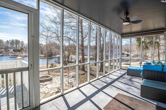 unfurnished sunroom featuring a water view and ceiling fan