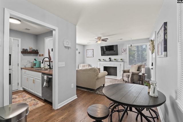 living room with baseboards, visible vents, dark wood finished floors, wet bar, and a high end fireplace