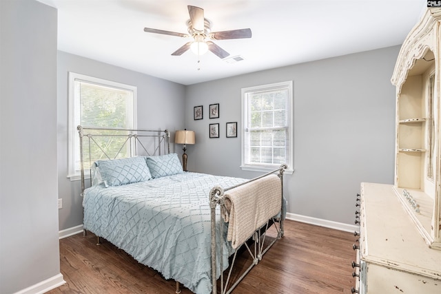 bedroom featuring dark wood-type flooring, multiple windows, visible vents, and baseboards