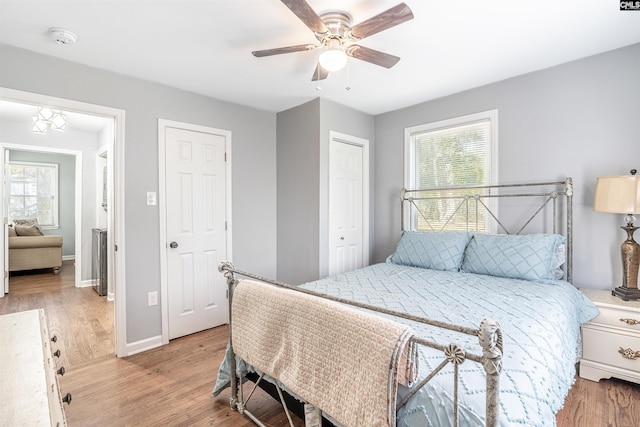 bedroom with multiple windows, light wood-type flooring, and a ceiling fan