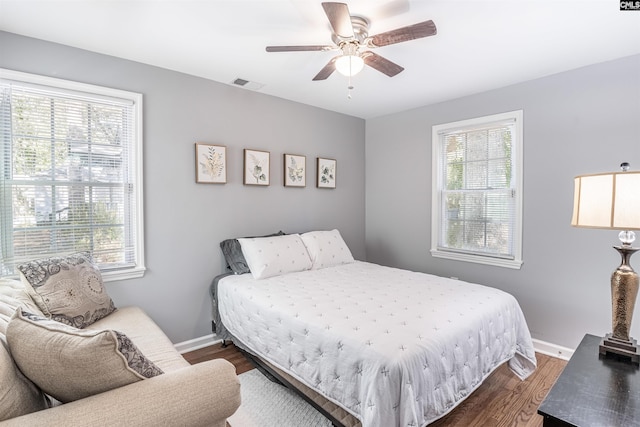 bedroom featuring a ceiling fan, baseboards, visible vents, and dark wood-type flooring