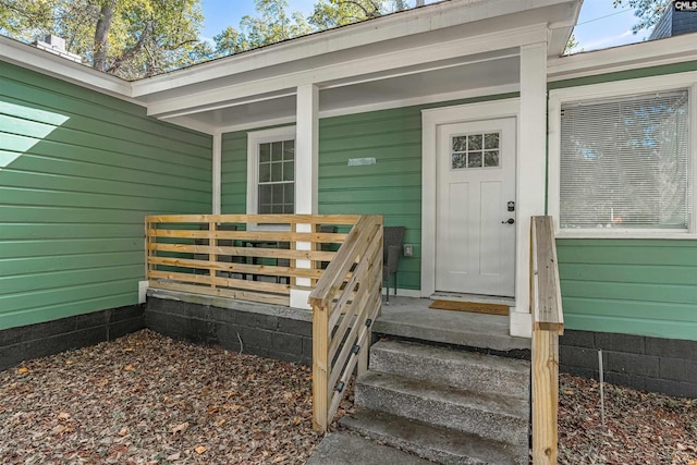 view of exterior entry featuring covered porch