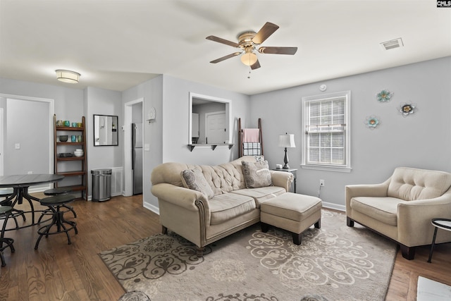 living room with baseboards, a ceiling fan, and wood finished floors