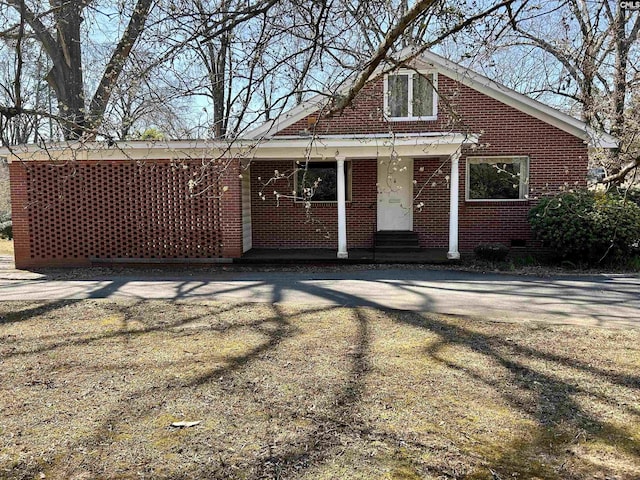 back of property with crawl space and brick siding