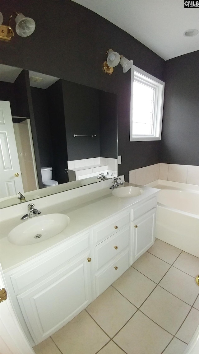 full bath with double vanity, a garden tub, tile patterned flooring, and a sink