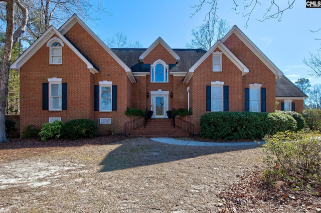 traditional-style home with brick siding, crawl space, and a shingled roof