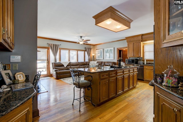 kitchen featuring light wood-style floors, a kitchen bar, open floor plan, and dishwasher