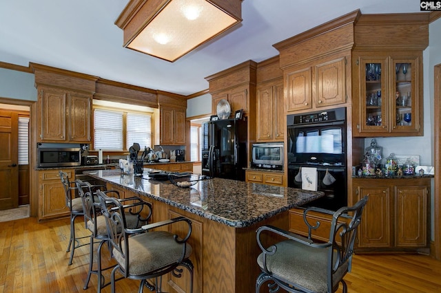 kitchen with brown cabinets, black appliances, and a breakfast bar