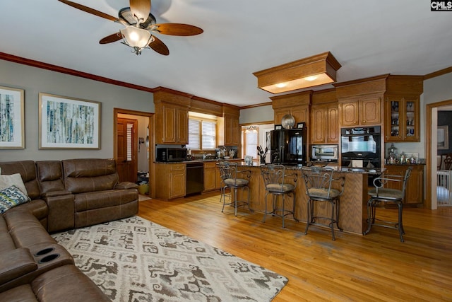 living room with light wood-type flooring, crown molding, and ceiling fan