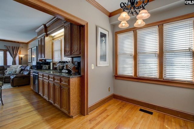 kitchen featuring visible vents, ornamental molding, light wood-style floors, dishwasher, and baseboards