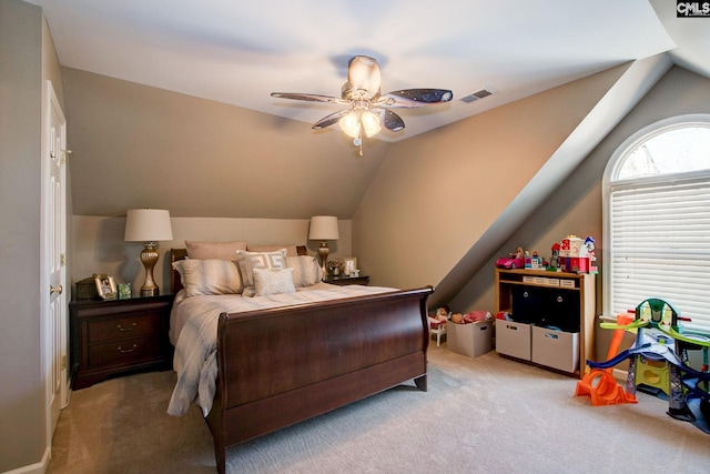 bedroom with carpet floors, visible vents, vaulted ceiling, and ceiling fan