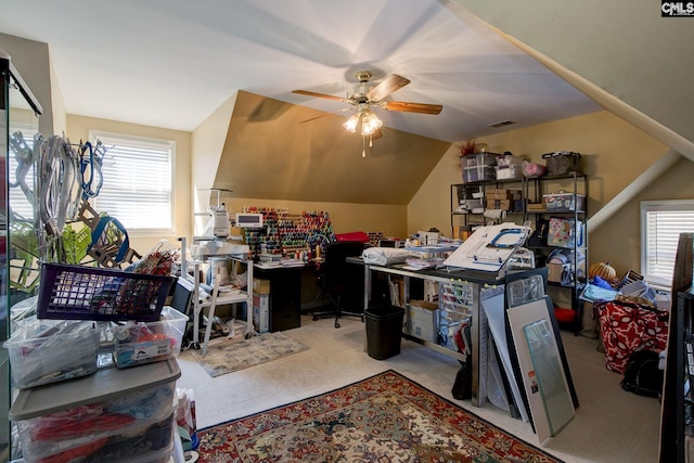 carpeted office featuring a healthy amount of sunlight, vaulted ceiling, visible vents, and ceiling fan