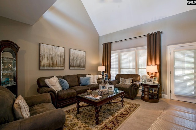 carpeted living room featuring high vaulted ceiling