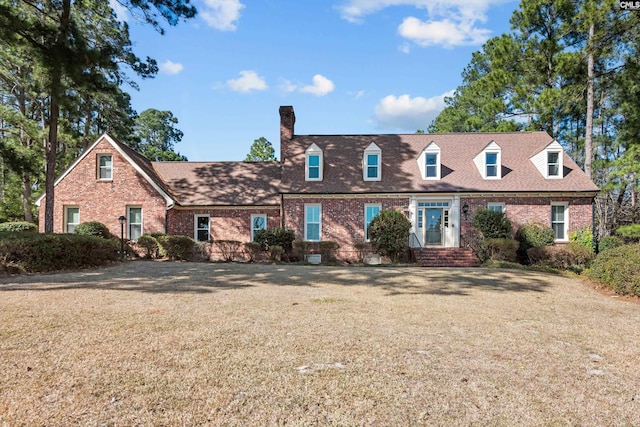 cape cod-style house with a front lawn, brick siding, and roof with shingles