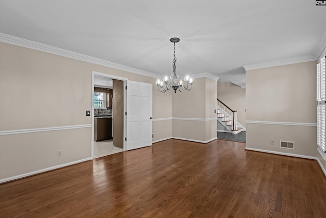 unfurnished room with visible vents, crown molding, stairway, and wood finished floors