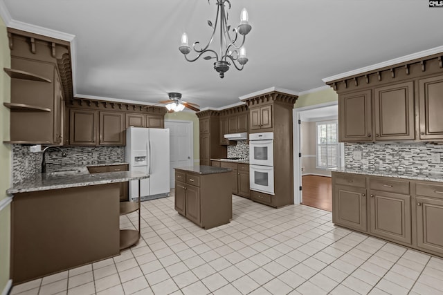 kitchen with open shelves, ceiling fan, a sink, white appliances, and under cabinet range hood